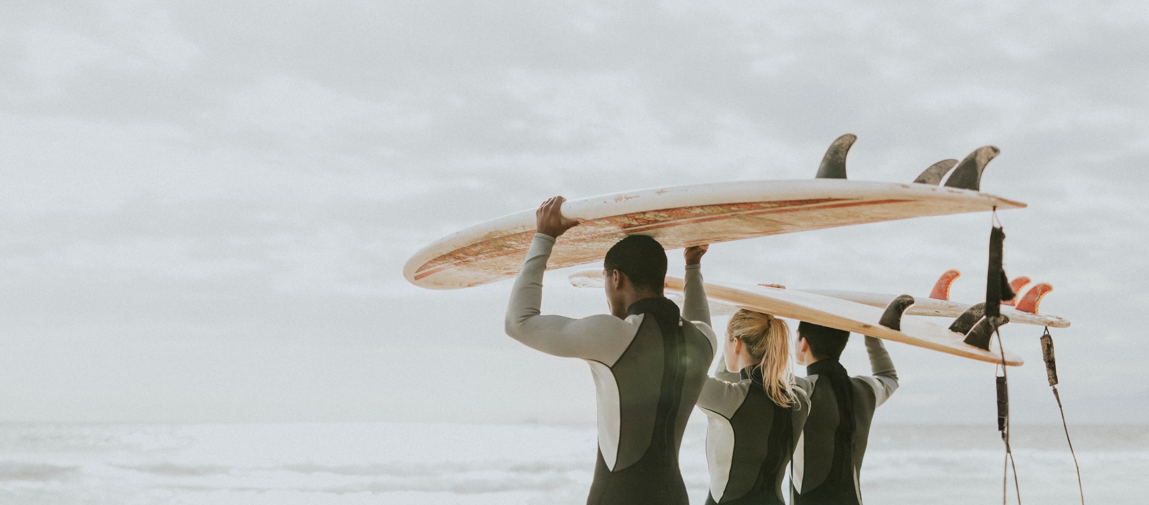 Surfers 3 with boards on heads Adobe Stock OEM cropped compressed