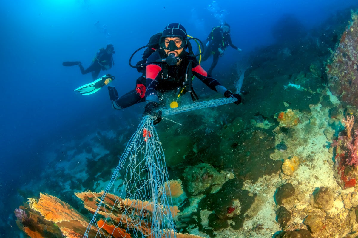 Divers on reef w fishing net AdobeStock 218534445 WSR